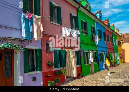 Reihe von Regenbogen buntes Haus mit Waschmaschinen hängen von den Fenstern in Burano in der Nähe von Venedig Italien Stockfoto