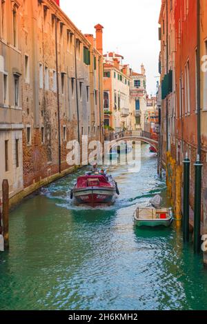 Arbeitsboot auf schmalen Kanal mit alten hohen Gebäuden Rio de La Pleta Venedig Italien gesäumt Stockfoto