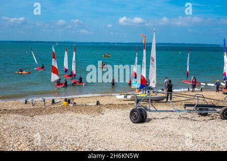 Topper Segelboote auf Solent Meer und Strand in Stokes Bay ist ein Kiesstrand in der Nähe von Gosport in Hampshire England. Stockfoto