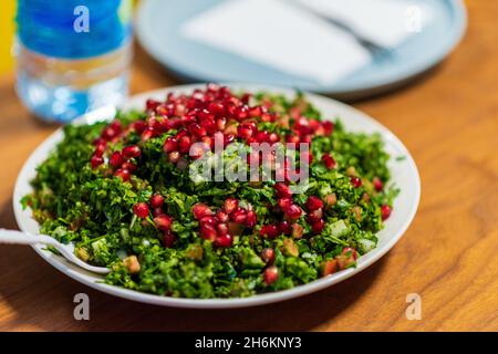 Tabbouleh ist ein levantinischer Salat, der hauptsächlich aus fein gehackter Petersilie Tabbouleh gehackter Petersilie Tabouli syrischer Salat, libanesischer Salat und türkischer Salat hergestellt wird. Hochwertige Fotos Stockfoto