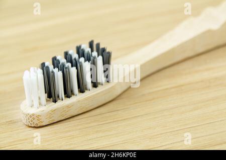 Bambuszahnbürste auf einem hölzernen Bambusbrett Stockfoto