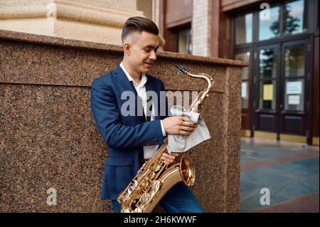 Saxophonist posiert mit Saxophon beim Bauen Stockfoto