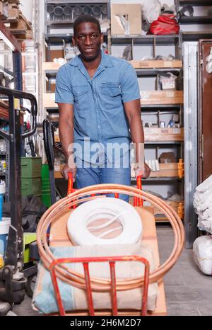 Glad African American schiebt Trolley-Wagen Stockfoto