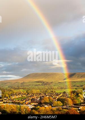 Ein Regenbogen vom Gelände des Clitheroe Castle, Lancashire, Großbritannien, mit Blick über die Stadt in Richtung Pendle Hill. Stockfoto