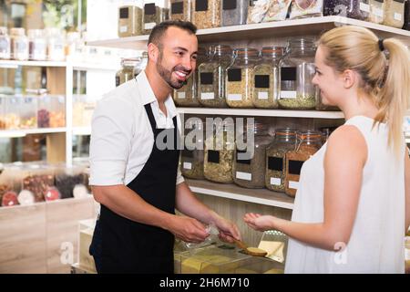 Männlicher Verkäufer im Geschäft mit ökologischen Gütern. Stockfoto