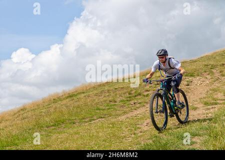 Der kaukasische Mann fährt mit seinem Mountainbike die Malvern-Hügel hinunter Stockfoto