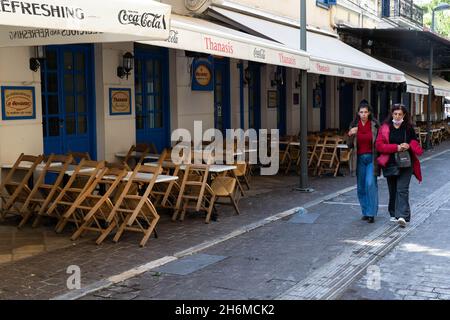 Athen, Griechenland. November 2021. Am 16. November 2021 laufen die Menschen an einem geschlossenen Restaurant in Athen, Griechenland, vorbei. Restaurants und Cafés in ganz Griechenland blieben am Dienstag geschlossen, während in Athen eine Demonstration stattfand, in der weitere staatliche Unterstützung im Rahmen der neuen COVID-19-Beschränkungen gefordert wurde, die von der Regierung im Herbst dieses Jahres eingeführt wurden, um den jüngsten Anstieg der Infektionsraten zu bekämpfen. Quelle: Marios Lolos/Xinhua/Alamy Live News Stockfoto