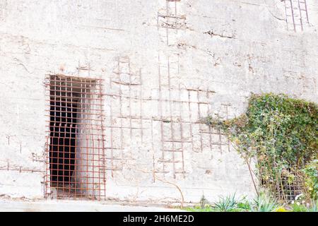 Ein Eisengitter am Eingang zu einem alten zerbröckelnden Gebäude. Architektur und Bauwesen. Stockfoto