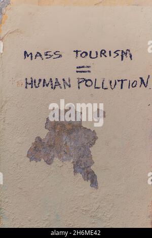 LISSABON, PORTUGAL - 10. OKTOBER 2017: Text Massentourismus menschliches Polluion an einer Wand im Alfama-Viertel von Lissabon, Portugal Stockfoto