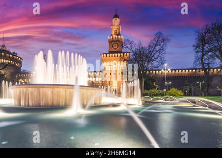 Schloss Sforza mit einem Brunnen bei Nacht. Schöne Beleuchtung des Gebäudes in warmen Farben. Mailand Italien Stockfoto