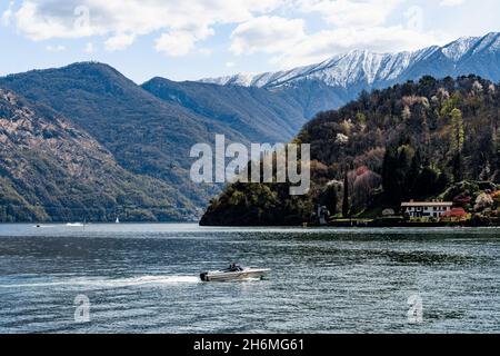 Motorboot fährt am Comer See vorbei an der Küste. Italien Stockfoto