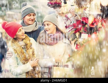 Dreiköpfige Familie mit Teenagermädchen, die Blumendekorationen auf dem Markt wählen. Geringe Schärfentiefe Stockfoto