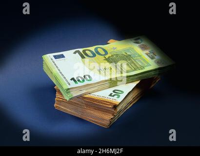 50- und 100-Euro-Banknoten mit schattiertem Hintergrund Stockfoto