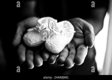 Baby Booties in den Händen seines Vaters Stockfoto