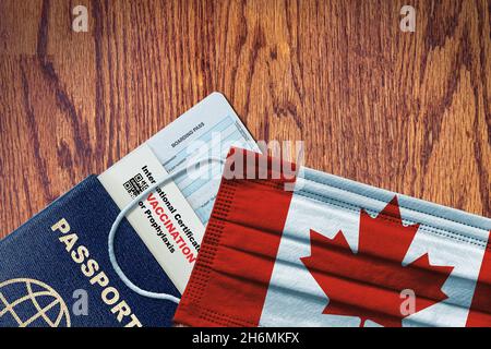 Kanada neue normale Reise mit Pass, Bordkarte, Gesichtsmaske mit kanadischer Flagge und Zertifikat der COVID-19-Impfung. Impfpass-Konzept Stockfoto