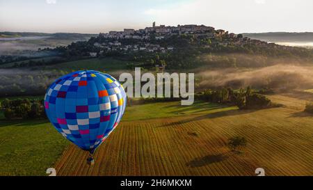 Ballonstart über dem mittelalterlichen Dorf Cordes-sur-Ciel im Süden Frankreichs. Blick von hinter dem Ballon auf das Dorf Cordes. Stockfoto