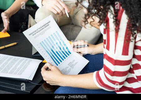 Mittlerer Abschnitt einer jungen Frau, die eine Grafik untersucht Stockfoto