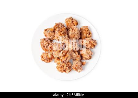 Gefrorene halbgekochte Hähnchenflügel auf einem weißen Teller auf weißem Hintergrund.Fast Food, Convenience Food. Stockfoto