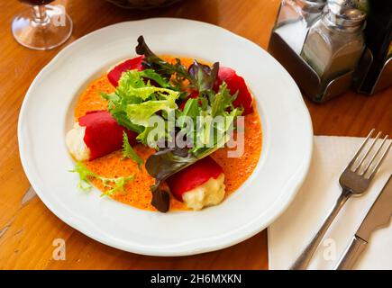 Leckere gefüllte Piquillo-Paprika mit Kabeljau-Brandade in Sauce Stockfoto