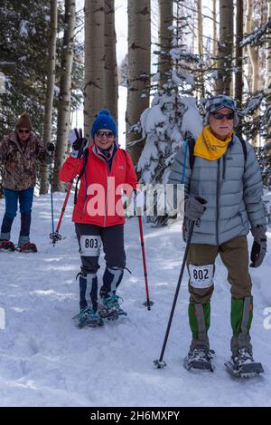 Drei Senioren in Schneeschuhen Rennen in der Chama Chile Ski Classic auf einem Weg in einem Hain von Espenbäumen in den südlichen San Juan Mountains . Stockfoto