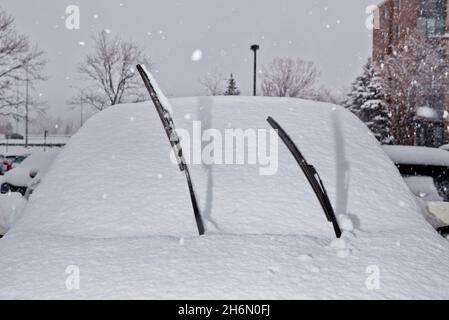 Windschutzscheibenwischer, die während des Winters in Longueuil, Quebec, Kanada, von einem schneebedeckten Auto aufstehen. Stockfoto