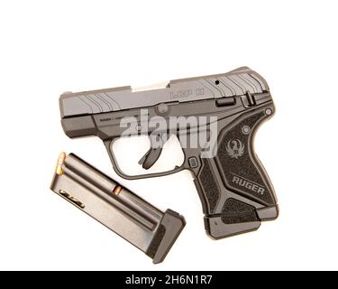 Eine halbautomatische 10-Schuss-Pistole Ruger LCP II im Kaliber .22 LR mit einem extra geladenen Magazin, isoliert auf Weiß. Stockfoto