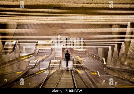 Ein Mann fährt die Rolltreppen in einer Metrostation in Montreal, Quebec, Kanada, herab Stockfoto
