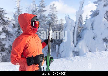 Skifahren. Skimorträt der Frau Alpin Skifahrer Haltungen Skier tragen Helm, coole Skibrille und Hardshell Winterjacke und Skihandschuhe an kalten Tag in Stockfoto