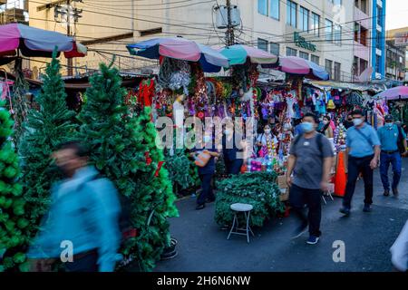 San Salvador, El Salvador. November 2021. Die Leute laufen an einem Geschäft vorbei, in dem Weihnachtsdekorationen verkauft werden. (Foto von Camilo Freedman/SOPA Images/Sipa USA) Quelle: SIPA USA/Alamy Live News Stockfoto