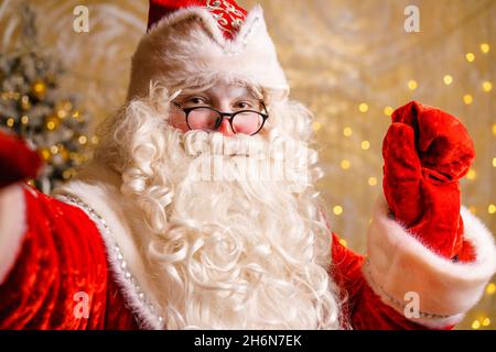 Der weihnachtsmann nimmt während der weihnachtszeit mit dem Mobiltelefon Selfie auf oder kommuniziert per Videokommunikation. Ein luxuriöses weihnachtsgeschenk oder ein Geschenk für gutes Benehmen. Neues Jahr. Stockfoto