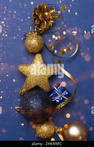 Schöne Gold Silber Dekorationen Weihnachtsspielzeug auf einem dunkelblauen Hintergrund Close-up Draufsicht Stockfoto