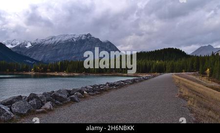 Schöner Blick auf den Stausee Upper Kananaskis Lake in den Rocky Mountains in Alberta, Kanada in der Herbstsaison an bewölktem Tag mit Staudamm und Wald. Stockfoto