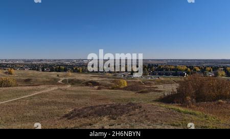 Wunderschöner Panoramablick über den Nose Hill Park im Norden von Calgary, Alberta, Kanada im Herbst mit farbenfrohen Wiesen, Parkplätzen und Flughafen. Stockfoto