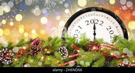 Neujahrsuhr 2022 und Weihnachtsgirlande. Stockfoto