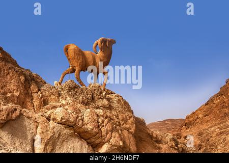 Bergoase Chebik, Sahara-Wüste, Berggipfel in der Wüste mit einer Skulptur einer Bergziege. Stockfoto