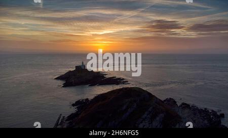 Swansea, Großbritannien. November 2021. Die Sonne geht heute Morgen über dem Mumbles Lighthouse auf der Gower Peninsula in der Nähe von Swansea auf. Quelle: Phil Rees/Alamy Live News Stockfoto