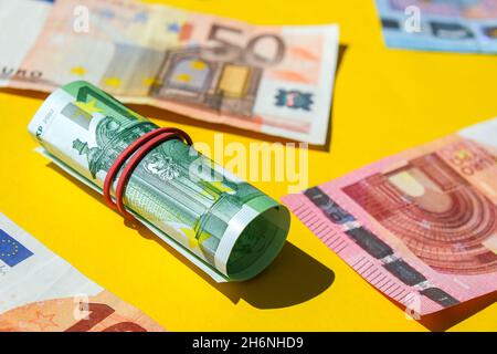 Nahaufnahme der Euro-Geldrolle. Euro-Banknote Set Cash Money - EU-Währung. Gerollt mit Euro-Scheinen aus Gummi. Banknoten sind unterschiedlich aufeinander gestapelt Stockfoto