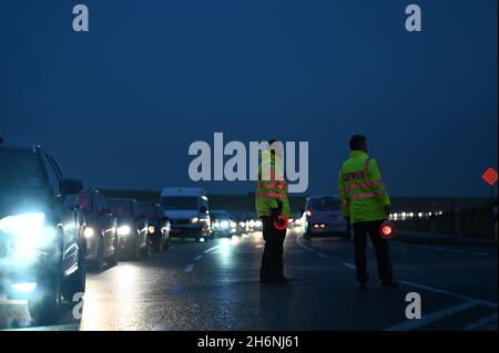 Leer, Deutschland. November 2021. Vor der Jann Berghaus Brücke über die Ems hat sich durch einen Warnstreik ein langer Stau gebildet. Polizeibeamte regulieren den Verkehr. Im anhaltenden Lohnstreit für die Staatsbediensteten setzte die Gewerkschaft Verdi ihre Warnstreiks in Niedersachsen fort. Mitarbeiter des Geschäftsbereichs Aurich des Niedersächsischen Landesamtes für Straßenbau und Verkehr (NLStBV) verließen die bewegliche Brücke zusammengefaltet. (To dpa 'wieder Warnstreiks im öffentlichen Dienst - Brücke in leer geschlossen') Quelle: Lars-Josef Klemmer/dpa/Alamy Live News Stockfoto