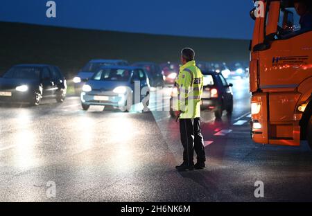 Leer, Deutschland. November 2021. Vor der Jann Berghaus Brücke über die Ems hat sich durch einen Warnstreik ein langer Stau gebildet. Polizeibeamte regulieren den Verkehr. Im anhaltenden Lohnstreit für die Staatsbediensteten setzte die Gewerkschaft Verdi ihre Warnstreiks in Niedersachsen fort. Mitarbeiter des Geschäftsbereichs Aurich des Niedersächsischen Landesamtes für Straßenbau und Verkehr (NLStBV) verließen die bewegliche Brücke zusammengefaltet. (To dpa 'wieder Warnstreiks im öffentlichen Dienst - Brücke in leer geschlossen') Quelle: Lars-Josef Klemmer/dpa/Alamy Live News Stockfoto