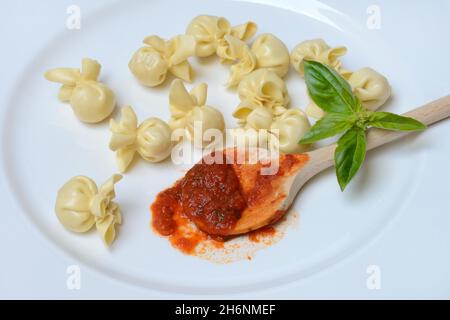 Saccottini, italienische Pasta auf dem Teller und Kochlöffel mit Tomatensauce, Pasta Stockfoto