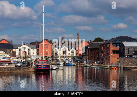Detailreiche, farbenfrohe Ansicht der Gebäude an der Piazza Terracina mit Booten, die auf glasiertem Wasser in Haven Banks im Exeter Canal Basin festgemacht sind Stockfoto