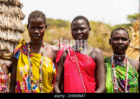 Traditionell gekleidete Mädchen aus dem Stamm der Toposa sitzen in einem Getreidespeicher, Eastern Equatoria, Südsudan Stockfoto