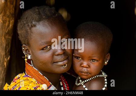 Frau mit ihrem Baby in einer Hütte, Toposa Stamm, Eastern Equatoria, Südsudan Stockfoto