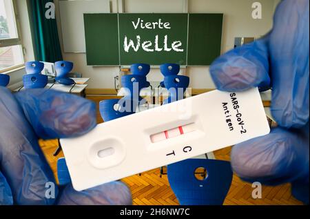 FOTOMONTAGE, positiver Antigenschnelltest, Tafel mit Aufschrift VIERTE WELLE, Klassenzimmer, Corona-Krise, Deutschland Stockfoto