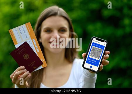 Symbol Foto Impfprivilegien, junge Frau mit App CovPass auf dem Smartphone mit digitalem europäischen Impfpass inklusive QR-Code Stockfoto