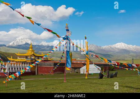 Goldene Dächer und Chöre eines tibetischen Klosters im Grasland von Tagong vor dem Berg Zhara Lhatse, Yala Snow Mountain, 5820m, Lhakang Stockfoto