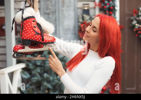 Frau erhielt Vintage-Schlittschuhe als Geschenk für Weihnachten für sportliche Aktivitäten während der Winterferien Stockfoto