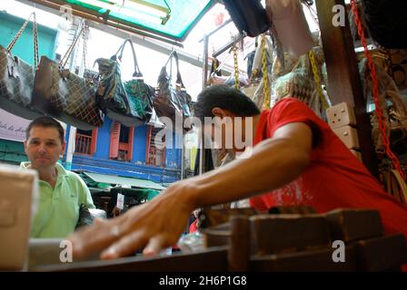 Eine burmesische Wanderarbeiterin, die Geldbörsen in Chinatown, Kuala Lumpur, Malaysia verkauft. Stockfoto