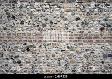 Detailreiche Aufnahme eines alten Steinwalles mit einer Mischung aus Ziegeln und Pflastersteinen. Verwendbar als Hintergrund oder Textur. Stockfoto