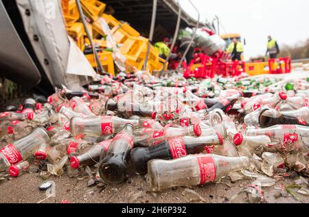 Talkau, Deutschland. November 2021. Getränkeflaschen liegen am Unfallort auf der Autobahn A24. Der Lastwagen hatte die Fahrbahn am Morgen verlassen und umgestrostet, wobei die Last auf der Fahrbahn verteilt wurde. (To dpa 'Truck loaded with beverage crates kippt auf der Autobahn') Quelle: Daniel Bockwoldt/dpa/Alamy Live News Stockfoto